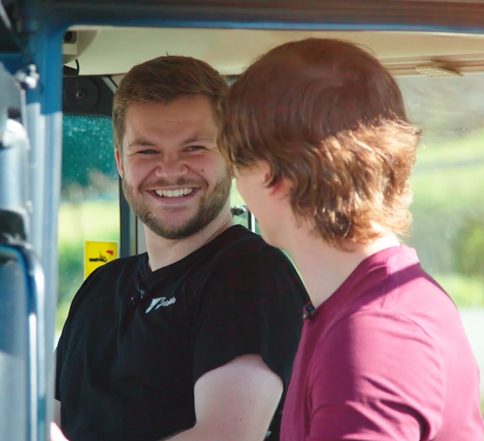 Bilde av to mennesker i en traktor. Utklipp fra Steinkjerfilmen.
